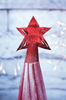 A red star tree topper made from metallic paper
