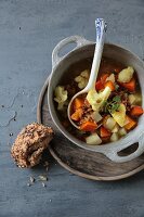 Vegetable stew with unripe spelt grains and a bread roll