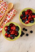 Summer berry salad served in hollowed out melon halves