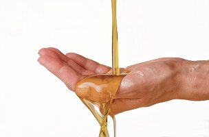Olive oil running over woman's cupped hand
