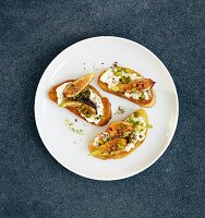 Crostini topped with ricotta, limes, Szechuan pepper, figs, rosemary honey and pistachio nuts