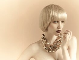 A young woman with platinum blonde pageboy hair style wearing an extravagant necklace
