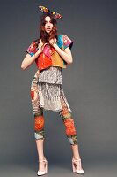 A young woman wearing an outfit made from various brightly coloured and patterned items of clothing