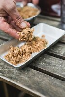 A soaked smoked mixture being transferred to an aluminium dish