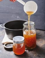 Homemade beef stock being transferred into jars