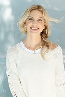 A young blonde woman wearing a natural-coloured woollen jumper