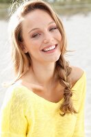 A young blonde woman wearing a yellow jumper