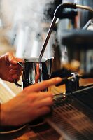 A barista foaming milk