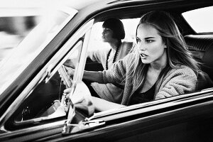 Two young women driving in car (black and white photo)