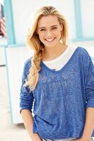 Junge blonde Frau in blau meliertem Shirt im Freien