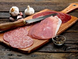 Antipasti on a wooden board: salami, Parma ham, Bresaola