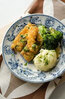 Breaded fish fillets with broccoli and mashed potatoes