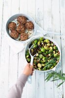 Brussels sprouts with green lentils and nuts served with meatballs