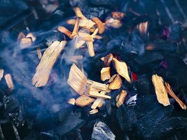 Gewässerte Räucherchips rauchen in der Glut