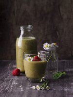 A raspberry and banana smoothies with leaves and daisies