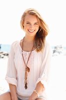 A young woman wearing shorts and a tunic on a beach