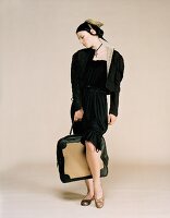 Junge Frau in schwarzem Kleid und Brokat-Jäckchen