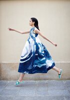 A young woman wearing a wide blue-and-white dress