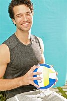 A young man holding a leather ball