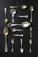 An arrangement of various spoons on a black surface