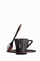 An espresso cup made of dark ebony wood with a spoon