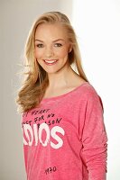 Junge blonde Frau in pinkfarbenem Print-Shirt