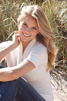 Young blonde woman wearing jeans and knitted top