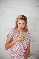 A woman drinking a green smoothie