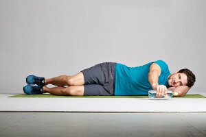 Lifting exercise – Step 1: lie on your side holding the water bottle in front of you