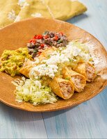 Taquitos with chicken, guacamole, queso fresco and bean purée (Mexico)