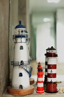 Three lighthouse ornaments in front of mirror