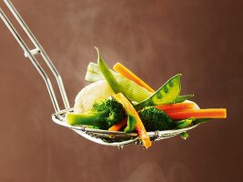 Cooked vegetables on a draining spoon