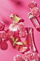 Various perfume bottles on a pink surface