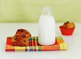 A bottle of milk and a banana and walnut muffin