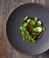 Dandelion salad with beetroot sprouts, red onions and boiled quail eggs