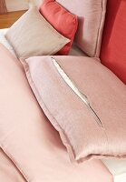A back cushion with an open zip on a bed
