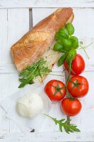 Ingredients for a mozzarella, tomato, basil and rocket sandwich