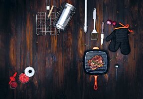 Barbecuing utensils and accessories on a dark wooden surface