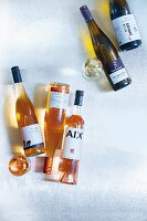 Roséwein und Weißwein in Flaschen und Gläsern