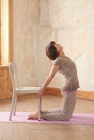 Holzhackerin (Yoga), Auf der Matte: Vor Stuhl knien, Wirbelsäule durchstrecken