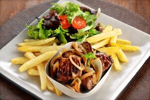 Steak with onions, salad and chips