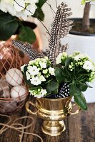 White Kalanchoe and spotted feathers in metal urn