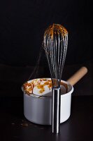 Caramel on a whisk and in a saucepan