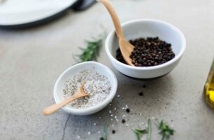 Salt and peppercorns in porcelain bowls