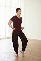 Der Tiger (Huxing, Qigong), Schritt 2: Beine beugen, Gewicht auf rechten Fuß, Fäuste formen