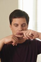 Abschlussmassage (Anmo, Qigong), Schritt 7: Zeigefinger unter Nase und Mund, im Wechsel zur Seite schieben