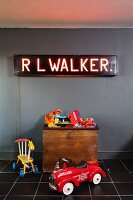 Neon light above toys on old wooden trunk