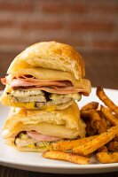 Warm ciabatta sandwiches with cheese, turkey ham, gherkins and chips