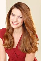 A smiling brunette woman in a red summer dress