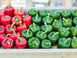 Red and green peppers in a wooden tray